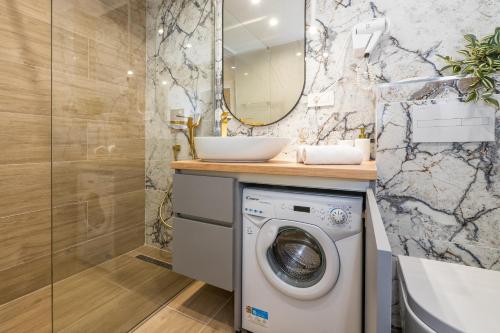 a bathroom with a washing machine and a mirror at Apartment Lokva Rogoznica 2973a in Lokva Rogoznica