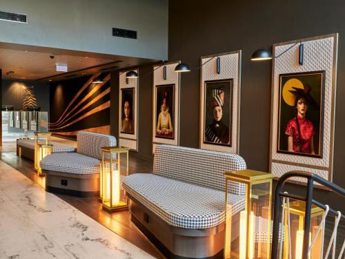 um lobby com bancos e quadros nas paredes em The Motley Hotel em Melbourne