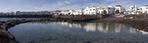 a large body of water in front of white buildings at LANZATE! in Tinajo