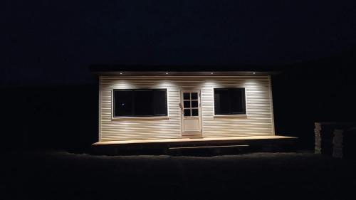 ein kleines Haus leuchtet nachts in der Unterkunft Brekkukot Cottages, Blönduós in Blönduós