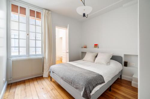 une chambre blanche avec un lit et une fenêtre dans l'établissement Luxury Living à Montorgueil, à Paris