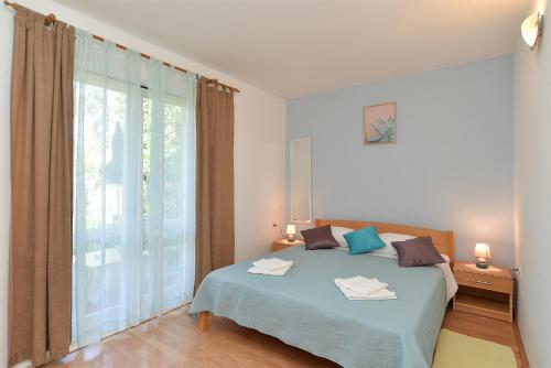 ein Schlafzimmer mit einem Bett und einem großen Fenster in der Unterkunft Apartments with a parking space Kukci, Porec - 20797 in Poreč