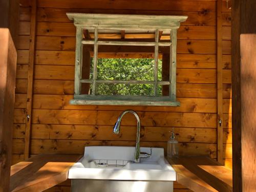 baño con lavabo y ventana en Boho Bungalow en Nelson