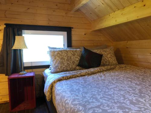 ein Schlafzimmer mit einem Bett in einem Blockhaus in der Unterkunft Boho Bungalow in Nelson