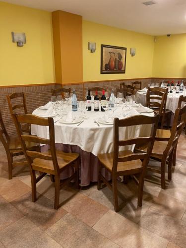 uma sala de jantar com uma mesa com garrafas de vinho e cadeiras em EL RINCON DE TOÑO em Pomar