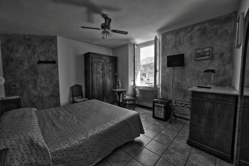 a bedroom with a bed and a ceiling fan at Locanda La Pergola in Bellagio