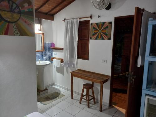 La salle de bains est pourvue d'une table en bois et de toilettes. dans l'établissement Pousada do farol, à Jericoacoara