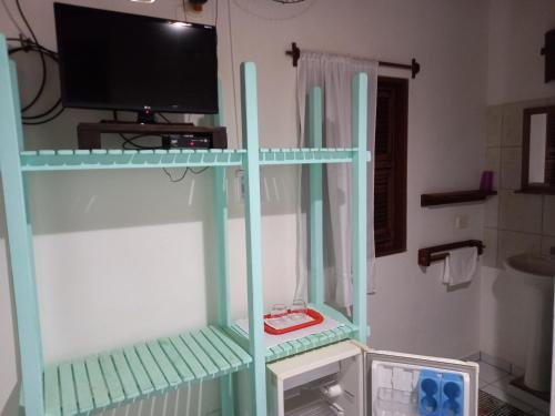 ジェリコアコアラにあるPousada do farolの電子レンジ付きの客室内の棚にテレビが備わります。