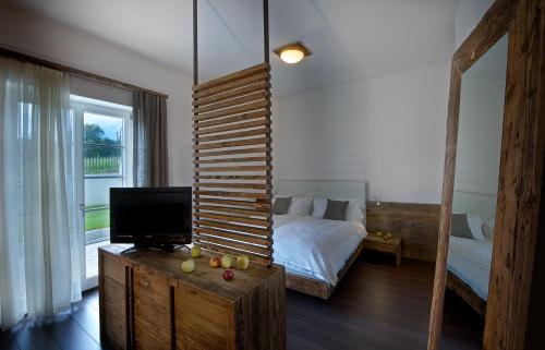 a bedroom with a bed and a television on a dresser at Agriturismo Florandonole in Fai della Paganella