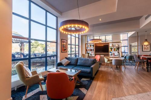 a living room with a couch and chairs and windows at Holiday Inn London Sutton by IHG in Sutton