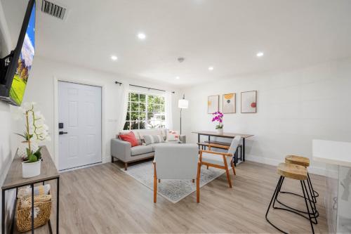 a living room with a couch and a table at 3 BR Smart home, close to airport, Fast WiFi, Patio, Grill & Free private parking in Miami