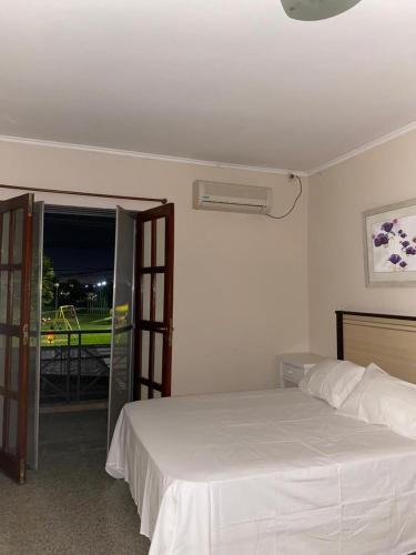 a bedroom with a white bed and a window at Casa Mía in Resistencia