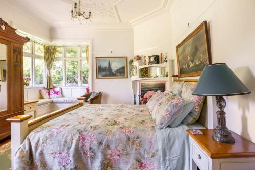 a bedroom with a bed and a lamp on a table at History @ Renall in Masterton