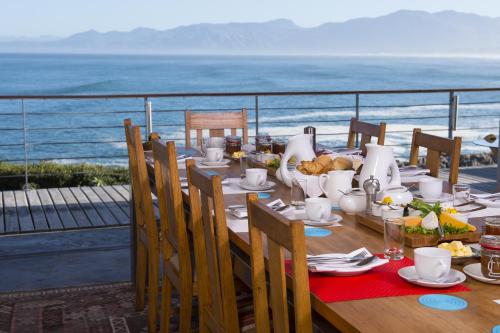 a table with food and a view of the ocean at Whalesong Lodge in Gansbaai