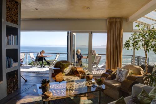 a living room with a view of the ocean at Whalesong Lodge in Gansbaai
