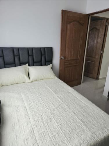 1 dormitorio con 1 cama y puerta de madera en Moderno y Amplio Apartamento en Medellín