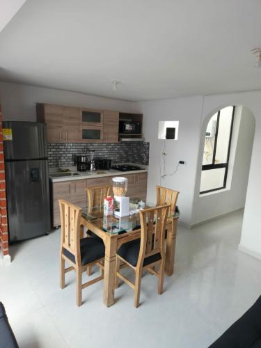 a kitchen with a table and chairs and a refrigerator at Moderno y Amplio Apartamento in Medellín