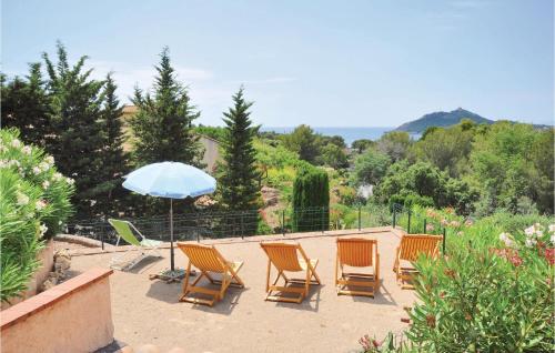 un groupe de chaises et un parasol sur une terrasse dans l'établissement Domaine De La Bastide Da, à Agay
