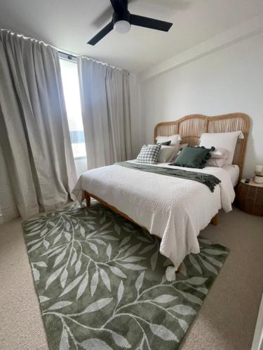 a bedroom with a bed and a green rug at Little Lane Apartments Comfortable, Chic New Apartment in Heart Of Fremantle Features Large balcony & Free car bay in Fremantle