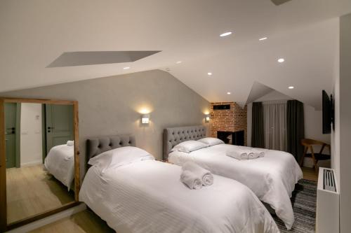 1 Schlafzimmer mit 2 Betten und weißer Bettwäsche in der Unterkunft Elegance Boutique Hotel in Korçë