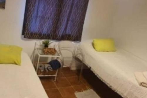 a small room with two beds and a window at LANZATE! in Tinajo