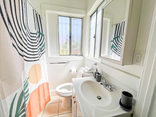 een badkamer met een wastafel, een toilet en een raam bij Peaceful 2 Bedroom Home - NH-WIN in Los Angeles