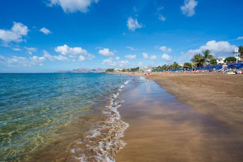 una playa con gente y el océano en un día soleado en LANZATE!, en Tinajo