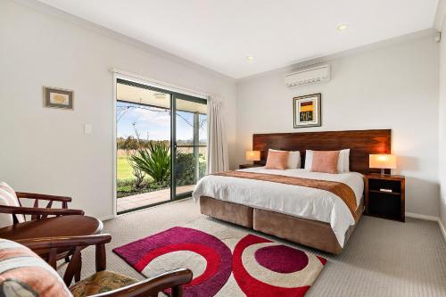 ein Schlafzimmer mit einem Bett und einem großen Fenster in der Unterkunft Talga Estate in Lovedale