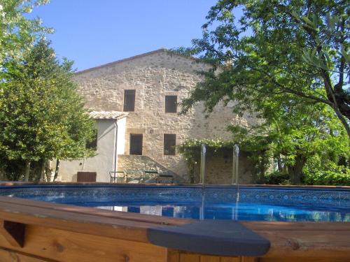 una casa in pietra con una piscina di fronte di Casa Demo a Fighine