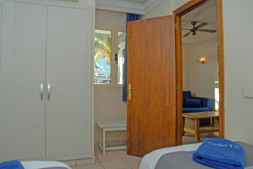 1 dormitorio con 1 cama y puerta de madera en Lufesa, en Puerto Rico de Gran Canaria