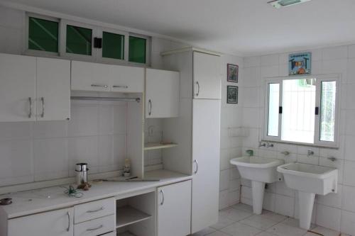 a white bathroom with a sink and a toilet at Casa Aurora Luz do Amanhecer in Rio de Janeiro