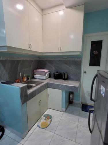 a kitchen with white cabinets and a counter top at Jens Samal Vacation Rental - Centrally Located - Fully Furnished 2br WIFI in Babak