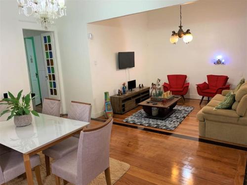 a living room with a table and red chairs at Casa Aurora Luz do Amanhecer in Rio de Janeiro