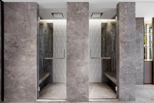 a bathroom with two shower stalls with mirrors at JW Marriott Shanghai Fengxian in Shanghai