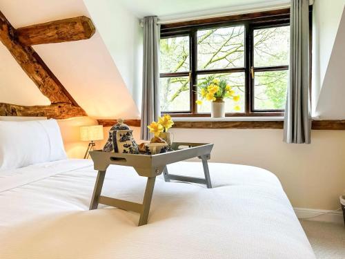 a bedroom with a bed and a table with flowers on it at Kite 2 - Uk6547 in Llanfihangel-Bryn-Pabuan