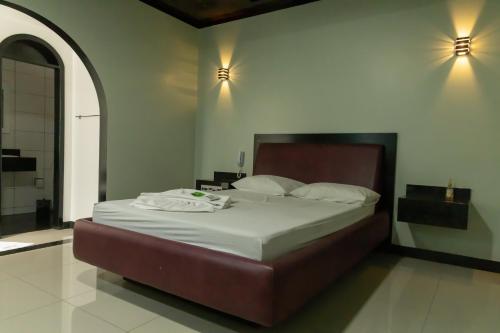 una camera da letto con un grande letto con lenzuola bianche di MOTEL 3 PEIXINHOS (Adults Only) a Blumenau