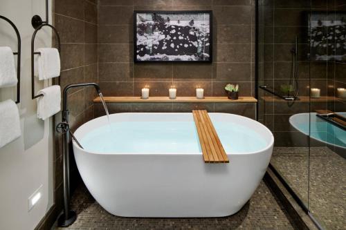 a bath tub in a bathroom with candles on it at The Cloudveil, Autograph Collection in Jackson