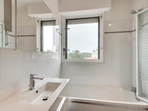 a white bathroom with a sink and a window at Studio spacieux 40m² à Anglet : proche plage, piscine, golf, pour 4 pers avec parking et wifi - FR-1-239-685 in Anglet