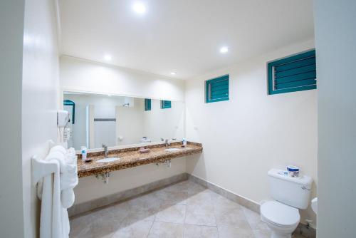 a bathroom with two sinks and a toilet and a mirror at Rostrevor Hotel in Christ Church