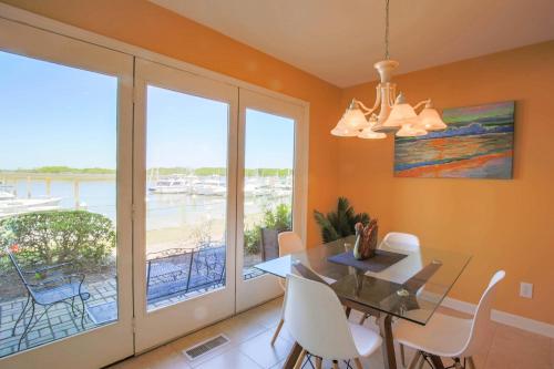 a dining room with a table and views of the ocean at Bohicket Marina Condo in Seabrook Island