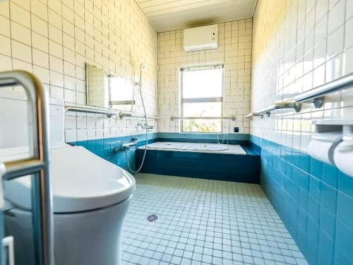 een blauwe en witte badkamer met een toilet en een bad bij Isumi seishinso - Vacation STAY 84726v in Isumi