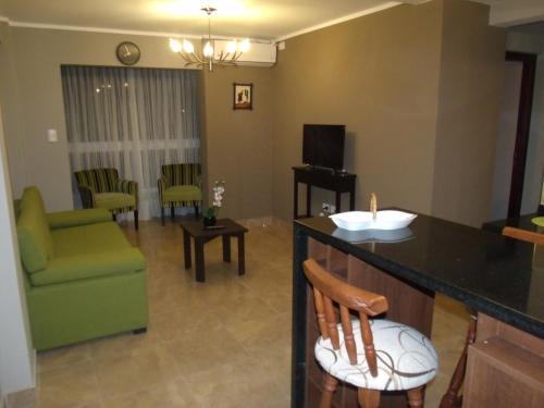 een woonkamer met een groene bank en een tafel bij Casa Magno Apart Boutique in Salta