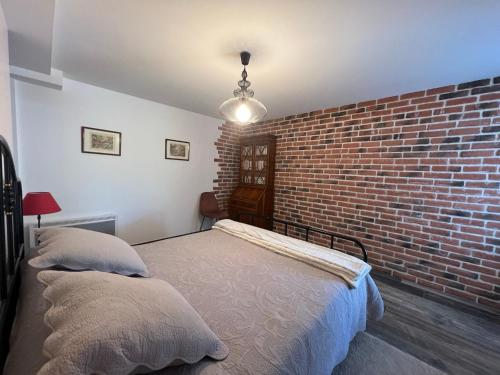 a bedroom with a brick wall and two beds at Charmant T3 avec piscine et parking dans maison basque - FR-1-239-927 in Ciboure
