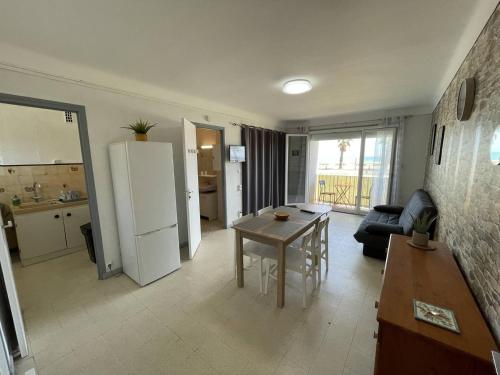 Il dispose d'une cuisine et d'un salon avec une table et un réfrigérateur. dans l'établissement Studio 4 pers. en bord de mer avec balcon, parking et animaux admis à Saint-Cyprien. - FR-1-106-94, à Saint-Cyprien