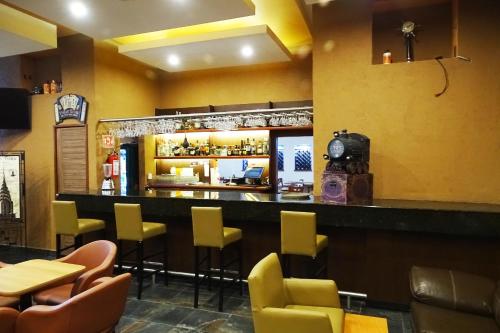 a bar in a restaurant with yellow walls and yellow chairs at Hotel Oslo in Mexico City
