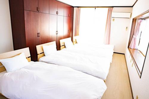 dwa łóżka w pokoju z białą pościelą w obiekcie 天満の宿不知火 w mieście Uki