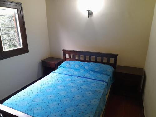 una camera da letto con un letto con un piumone blu e una finestra di El Mirador Los Nogales a Yala