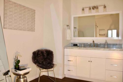 a bathroom with a sink and a chair and a mirror at Death Valley Hot Springs 2 Bedroom in Tecopa