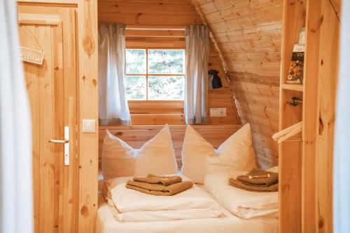 a room with two beds in a small room with a window at Frankenwald Chalets - Chalets in Wilhelmsthal