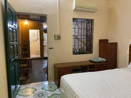 a bedroom with a bed and a desk and a window at T30 Hanoi Homestay, near Lotte Tay Ho, 25minutes to the airport in Hanoi